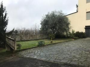 una recinzione accanto a un cortile con un albero di Casa Giulia a Vigliano d'Asti