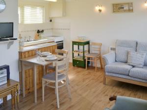 a kitchen and living room with a table and a couch at Silver Bream in Brundall