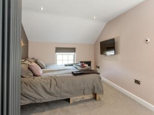 a bedroom with a bed and a tv on the wall at Ivy Cottage in Beck Hole