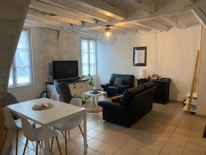 a living room with a couch and a table at Le Marais Vous - Duplex en centre-ville. in Provins