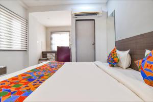 a bedroom with a large bed with a colorful blanket at Fabhotel Grand Blue in Indore +20 photos