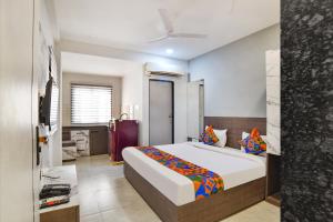 a bedroom with a large bed and a bathroom at Fabhotel Grand Blue in Indore