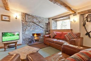 a living room with a couch and a fireplace at The Old Post Cottage, Coniston in Coniston