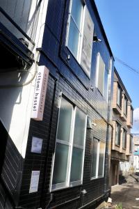 a black building with a sign on the side of it at attomi hostel in Sapporo