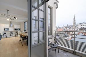 a kitchen and dining room with a view of the city at Magnifique Appartement 3 chambres vue Théâtre de la Monnaie in Brussels