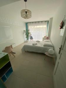 um quarto branco com uma cama e uma janela em Villa nature - spacieuse et moderne em Villemer