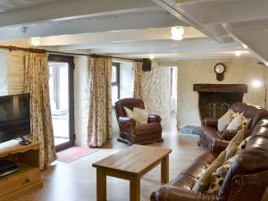 セント・アグネスにあるBannsvale Cottage - W43192のリビングルーム(革製家具、暖炉付)