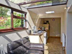 a living room with a leather couch in a tiny house at Bannsvale Cottage - W43192 in St. Agnes