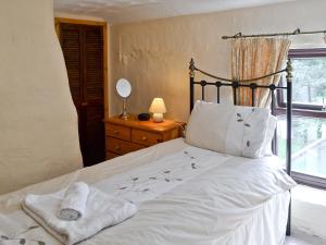 a bedroom with a bed with white sheets and a window at Bannsvale Cottage - W43192 in St. Agnes