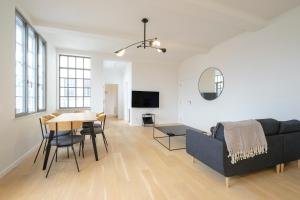 a living room with a couch and a table at Magnifique Appartement 3 chambres vue Théâtre de la Monnaie in Brussels