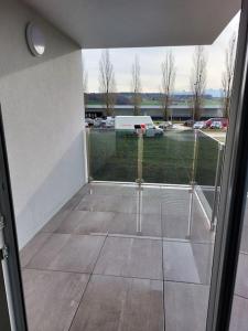an open door to a patio with a view of a parking lot at Appartement 2p1/2 pour couple ou famille in Romont