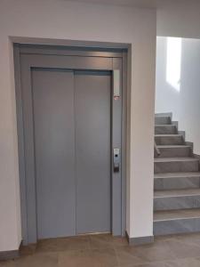 - une porte blanche dans un bâtiment avec des escaliers dans l'établissement Appartement 2p1/2 pour couple ou famille, à Romont