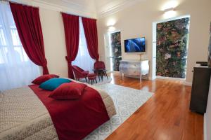 a bedroom with a bed with red curtains and a television at Rosetta Burger Queen in Cagliari