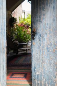 une porte ouverte sur une terrasse couverte avec un banc dans l'établissement Logis Saint-Léonard, à Honfleur