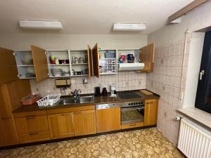 una pequeña cocina con armarios de madera y fregadero en WG in Homberg Efze, Monteurzimmer, 2 Erwachsene, 1 Doppelzimmer Nr 3 