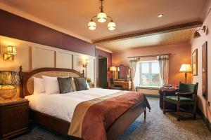 a bedroom with a large bed and a chair at Hope & Anchor in Hope Cove