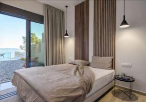 a bedroom with a bed and a large window at Villa Alliopi ein Blick für die Sinne in Kranidi