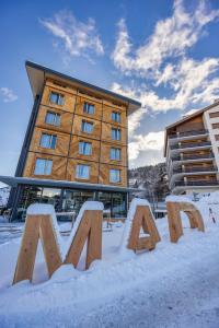 ein Schild im Schnee vor einem Hotel in der Unterkunft MAD Mount Hotel & Spa in Nendaz