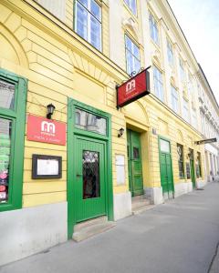 un edificio giallo con porte verdi su una strada di Renovated & Cozy - Close to Museumsquartier a Vienna