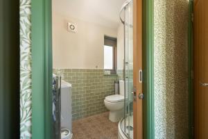 a bathroom with a toilet and a glass shower at Hope & Anchor in Hope Cove
