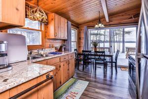 Una cocina con gabinetes de madera y un comedor. en Behnkes Bungalow, en Manitowish Waters