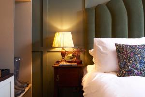 a bedroom with a bed with a lamp on a night stand at Hope & Anchor in Hope Cove