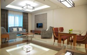 a living room filled with furniture and a large window at Millennium Executive Apartments Muscat in Muscat