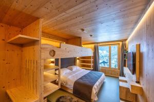 Cette cabane en rondins comprend des lits superposés et une télévision. dans l'établissement MAD Mount Hotel & Spa, à Nendaz