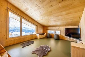 a room with a tv and a living room at MAD Mount Hotel & Spa in Nendaz