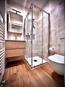a bathroom with a glass shower and a toilet at Welcome Traveller AMORE APARTMENTS in Bardolino +27 photos