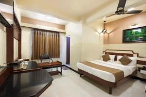 a hotel room with a bed and a desk at Mannars Yatri Nivas Hotel in Mysore
