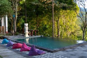 una piscina con almohadas coloridas alrededor en Puri Sunny Guesthouse, en Munduk