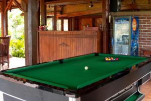 a green pool table with a ball on it at Puri Sunny Guesthouse in Munduk