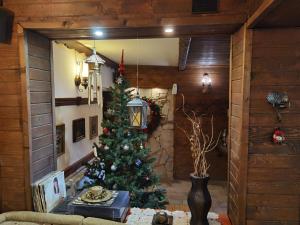a christmas tree in a living room with a table at Mira Guest House in Dobrinishte