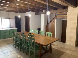 赫雷斯－德拉弗龍特拉的住宿－Santa Lucía，一间带木桌和绿色椅子的用餐室