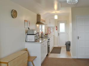 a kitchen with a sink and a microwave at Hafan in Aberffraw