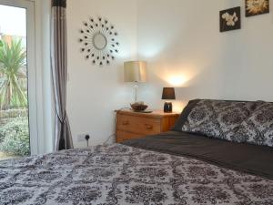 a bedroom with a bed and a lamp and a window at Hafan in Aberffraw