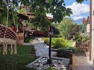 a garden with a lamp post in the yard at Mira Guest House in Dobrinishte