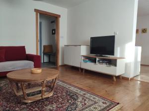 a living room with a table and a tv at Ubytovanie v Banskej Bystrici - dom s terasou in Banská Bystrica