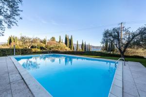 een zwembad met blauw water in een tuin bij Appartamento 34 in Toscolano Maderno