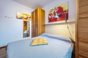 een slaapkamer met een bed en een schilderij aan de muur bij Appartamento 34 in Toscolano Maderno