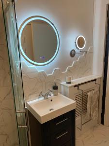 ein Badezimmer mit Waschbecken und Spiegel in der Unterkunft Stunning 3 bed seafront mansion building sleeps 6 adults or 8 with kids in Portrush