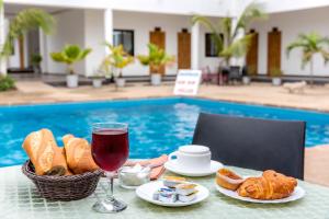una mesa con una cesta de pan y una copa de vino en Hôtel le Relais de Kolda, en Kolda
