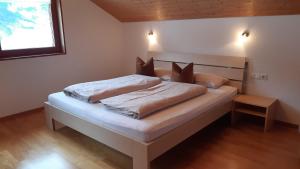 a bedroom with a bed with white sheets and pillows at Haus Erna Schoppernau in Schoppernau