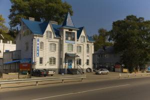 une grande maison avec une tourelle sur le côté d'une rue dans l'établissement Hotel Pribrezhnaya, à Kalouga
