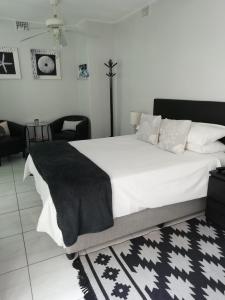 a bedroom with a large bed with a black and white rug at The Palm in Cape Town
