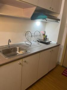 a kitchen counter top with a sink and a sink at Stylish 1BR with Wifi and Queen size bed in Grace Res in Manila
