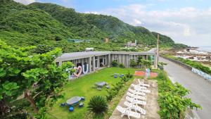 un edificio con un cortile con sedie da giardino bianche di 樂見海 a Green Island