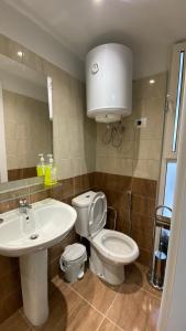 a bathroom with a white toilet and a sink at Kosta's Home in Tirana