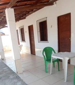 Pokój ze stołem i zielonym krzesłem w obiekcie Cantinho do Relax w mieście Itaparica